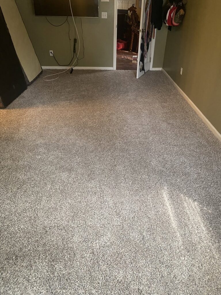 A newly installed grey carpet in a residential room by Factory Outlet Northside Flooring and More in Jacksonville, FL.