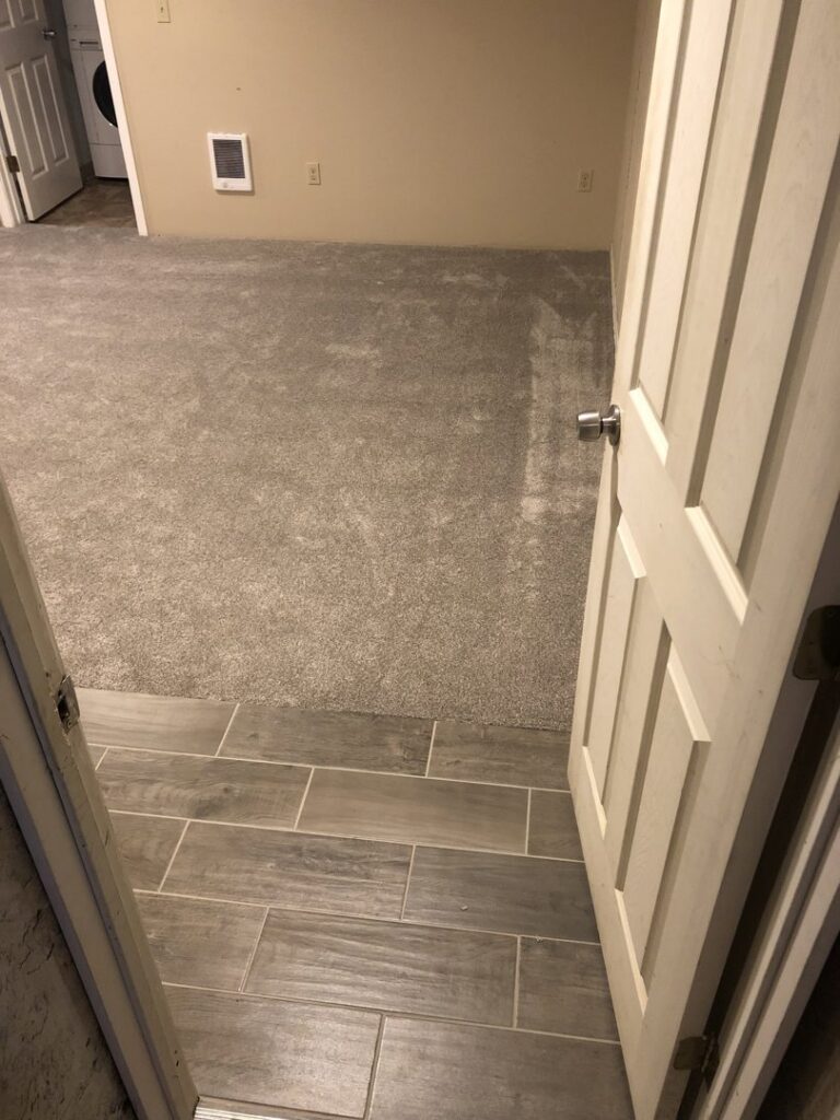 Newly installed grey carpet transitioning to tile flooring by MX Flooring in Vancouver, WA