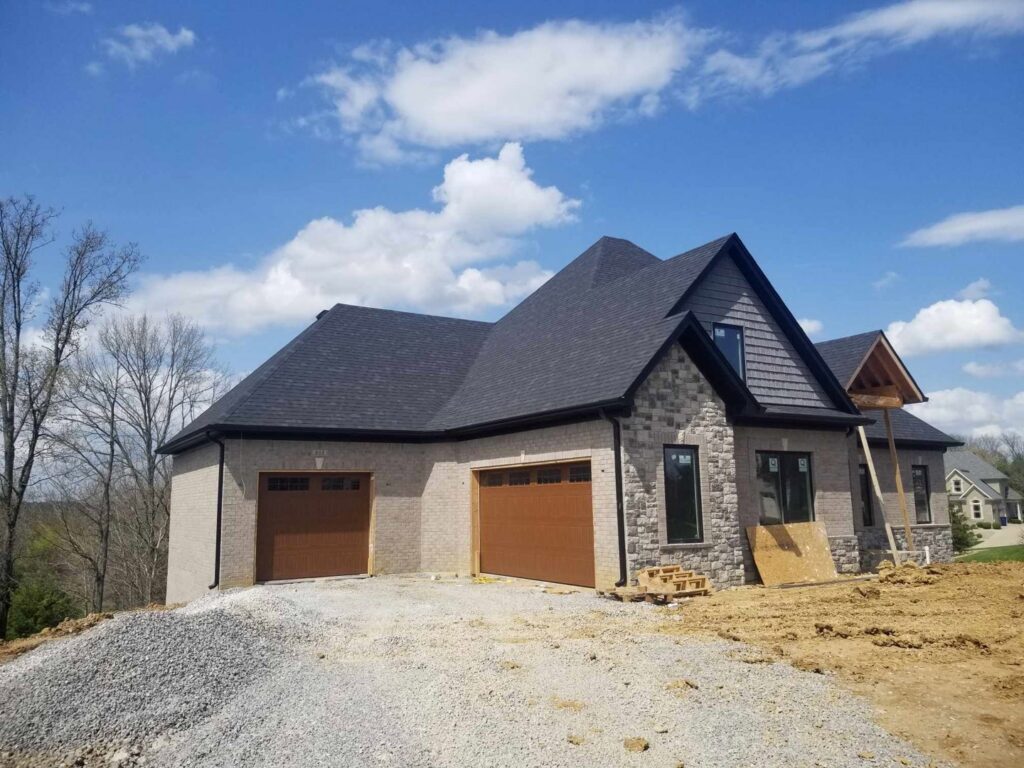 Two brown garage doors installed on a new home under construction by Honest Overhead Garage Doors in Elizabethtown, KY.