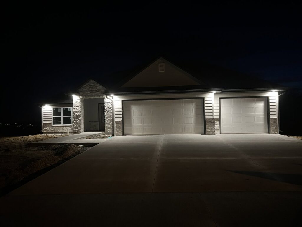 Exterior lighting installed on a newly built home at night by Pinnacle Electric Solutions in Port St. Lucie, FL.