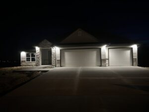 Exterior lighting installed on a newly built home at night by Pinnacle Electric Solutions in Port St. Lucie, FL.