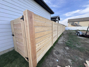 A new horizontal slat wooden fence with a matching gate installed by Nailed It Fencing in Williston, ND.