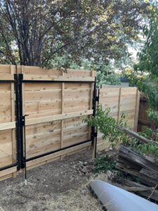 A newly installed modern horizontal slat wood fence with a matching gate by This And That Fence in Reno, NV.