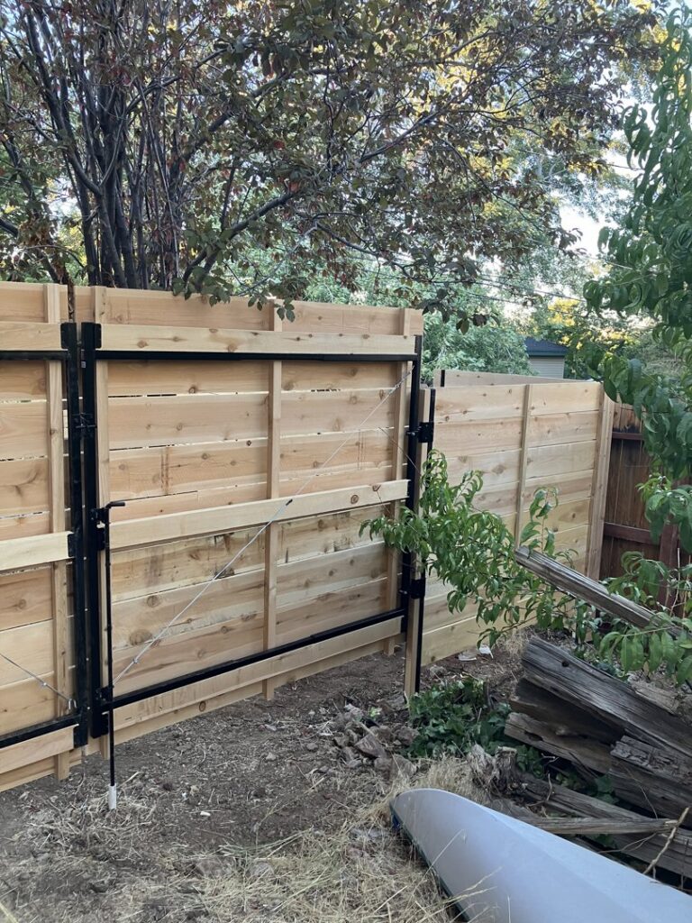 A newly installed modern horizontal slat wood fence with a matching gate by This And That Fence in Reno, NV.