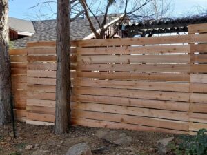 A newly installed horizontal slat wood fence in a residential backyard by Done Wright Fencing and Welding in Denver, CO.