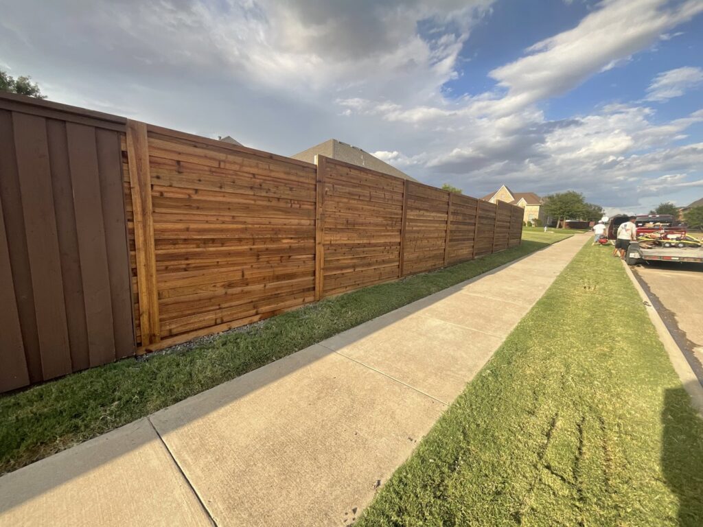 A newly installed horizontal wood fence running alongside a sidewalk, completed by G L Fence & Remodeling in Arlington, TX.