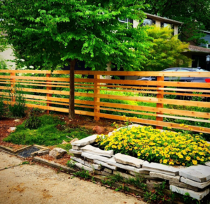 A newly installed modern horizontal slat wood fence in a residential yard by Tussing's Fence in Ann Arbor, MI.