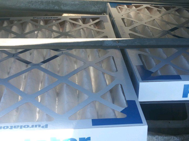 New Purolator air filters being installed in an HVAC system by A-OK Heating & Cooling in Concord, GA.