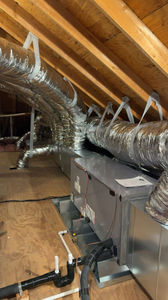 A newly installed HVAC air handler unit with connected ductwork in an attic by Moreau's Heating & AC in Lake Charles, LA.