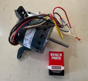 A new HVAC blower motor and a box of HVAC/R replacement parts, ready for installation by Bloomington Heating & Air in Bloomington, MN.