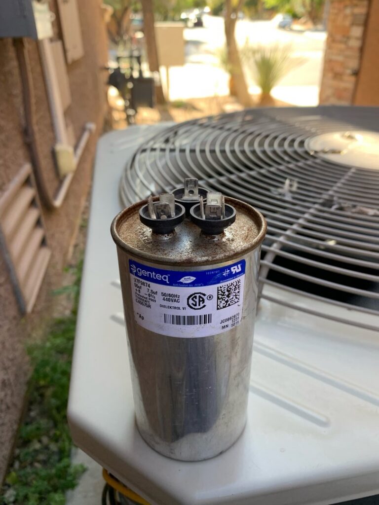 A new HVAC capacitor ready for replacement on an outdoor unit by Dakine Heating & Cooling, LLC in Las Vegas, NV.