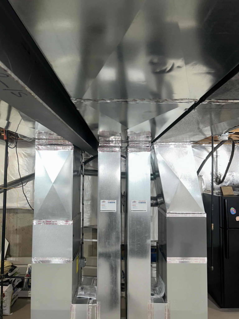 Newly installed HVAC ductwork running across a basement ceiling by Air For You Heating and Air in Joliet, IL.