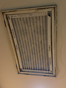 A new, clean HVAC air filter (14x24x1) installed in a ceiling return air vent by GUS' HVAC Services in Canton, GA.
