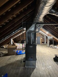 A new HVAC furnace installed in an attic with ductwork by Manny Services in Syracuse, NY.
