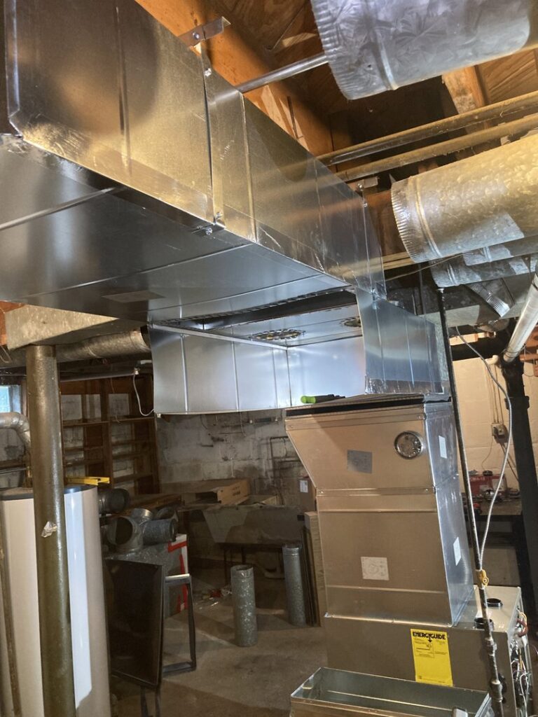 A new HVAC furnace and ductwork installed in a basement by Manny Services in Syracuse, NY.