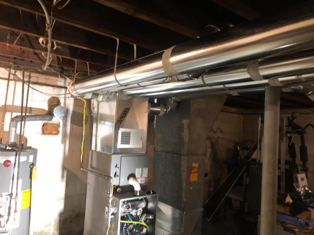 A new HVAC furnace installation with exposed internal components and ductwork by Allegheny General Contracting Services Heating and Cooling in Pittsburgh, PA.