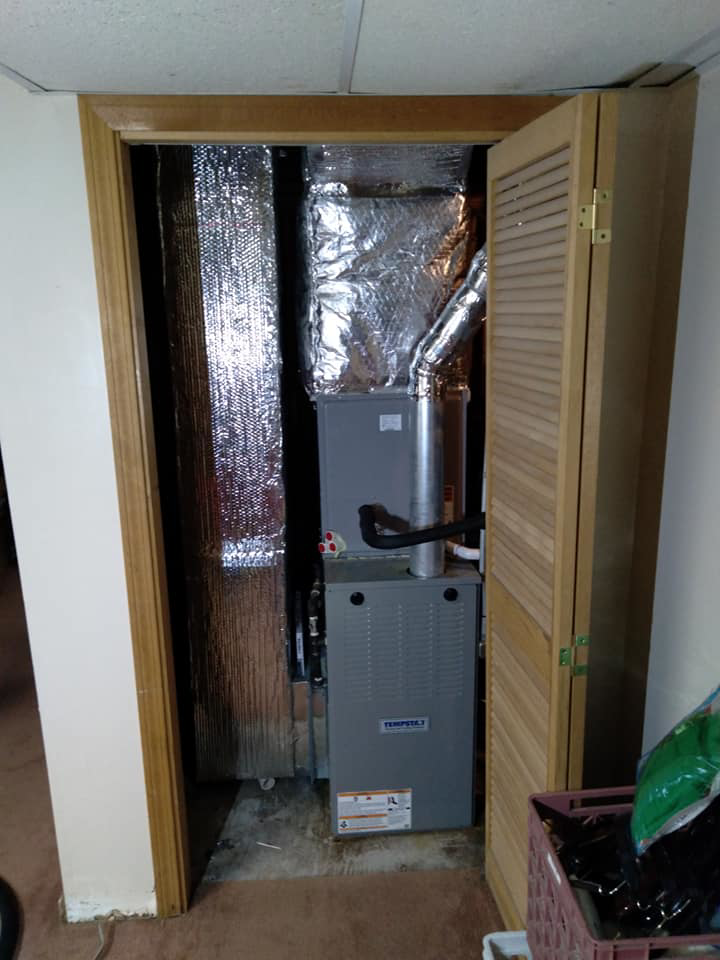 A newly installed indoor HVAC furnace and ductwork system in a closet by Global Sheetmetal Inc in Warwick, RI.