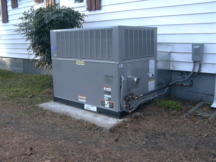 A newly installed outdoor HVAC unit next to a house by Collis Mechanical Services in Norfolk, VA