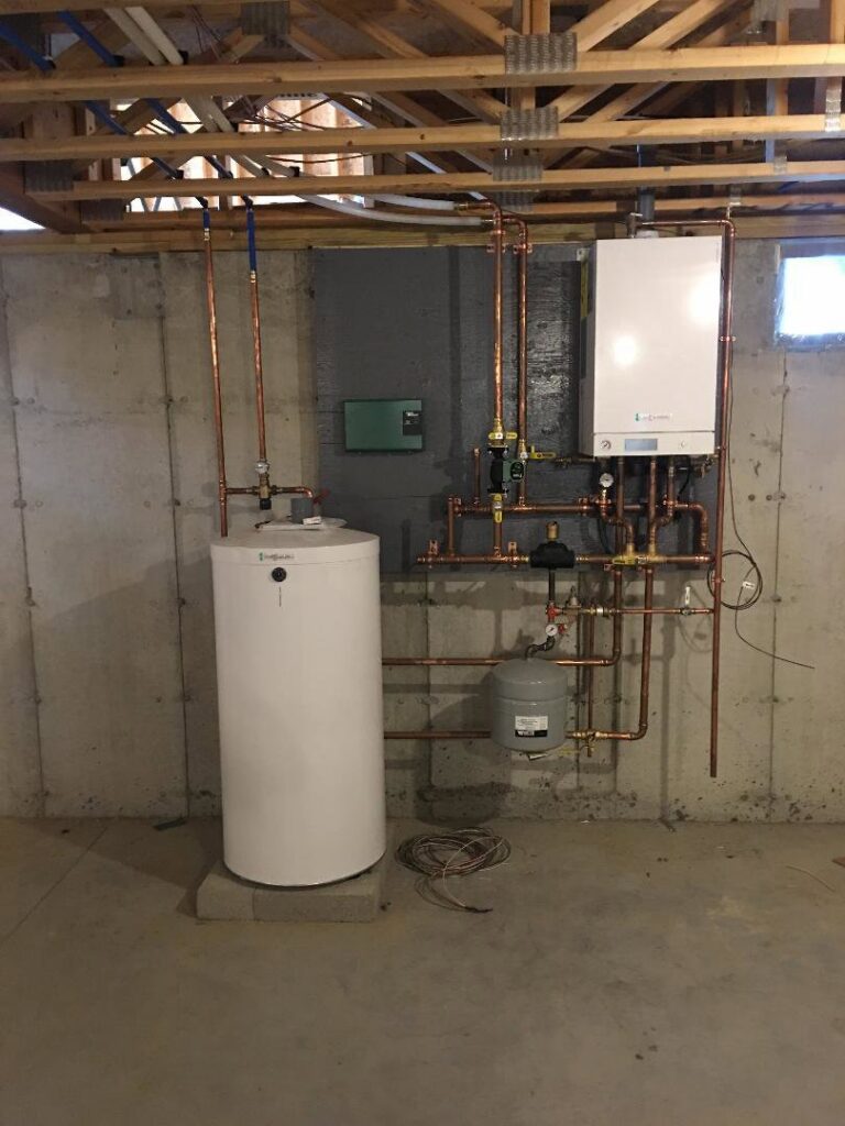 A new HVAC system installation featuring a wall-mounted boiler and a white water heater tank by Nate's Oil Burner Service in New Bedford, MA