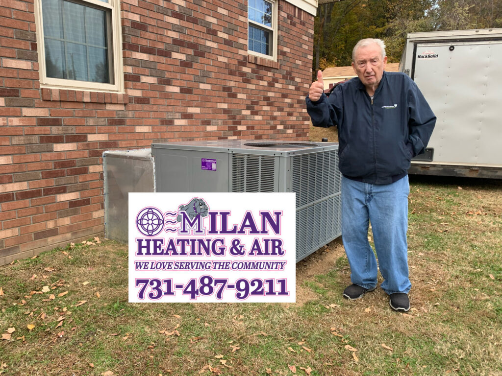 A satisfied customer giving a thumbs up next to a newly installed HVAC unit by Milan Heating & Air in Milan, TN.