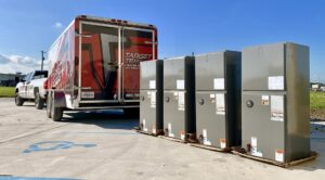 New HVAC outdoor units on pallets next to a Target Temp, LLC service truck and trailer in Houma, LA.