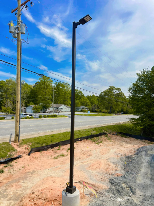 A newly installed LED street light pole with overhead utility lines by C.A Electrical & More in Greenville, SC.