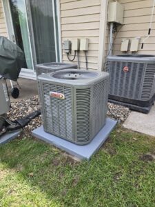 A newly installed Lennox outdoor air conditioning unit next to an older Rheem unit by Cyber Heating and Cooling in Bloomington, MN.