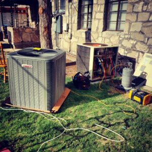 A new Lennox air conditioning unit being installed next to an old unit by Reading Plumbing, Heating & Air Conditioning in Roswell, NM