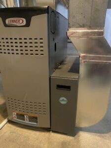 A new Lennox furnace unit connected to metal ductwork, indicating an HVAC installation by Crain Heating and Cooling in Jeffersonville, IN.