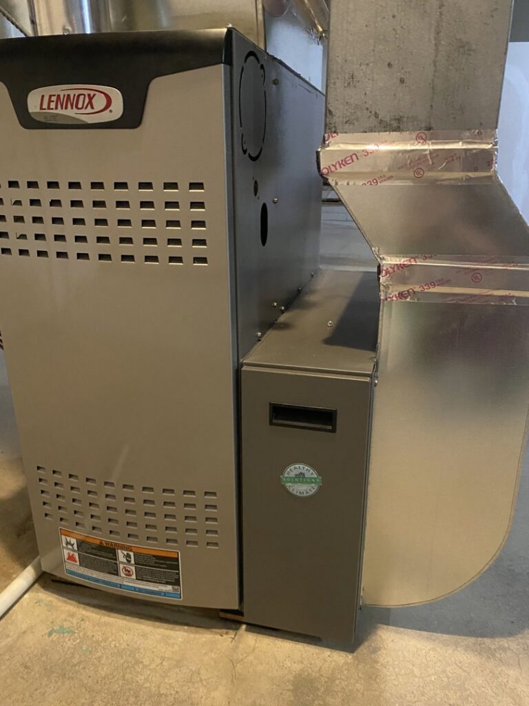 A new Lennox furnace unit connected to metal ductwork, indicating an HVAC installation by Crain Heating and Cooling in Jeffersonville, IN.