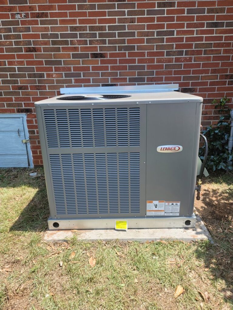 A newly installed Lennox outdoor air conditioning unit next to a brick building by Cordells Heating and Cooling in Greenville, SC.