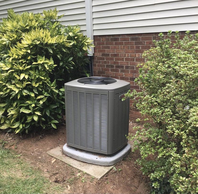 A newly installed Lennox outdoor HVAC condenser unit next to a residential home by Systematic Heating & Air in Winston-Salem, NC.