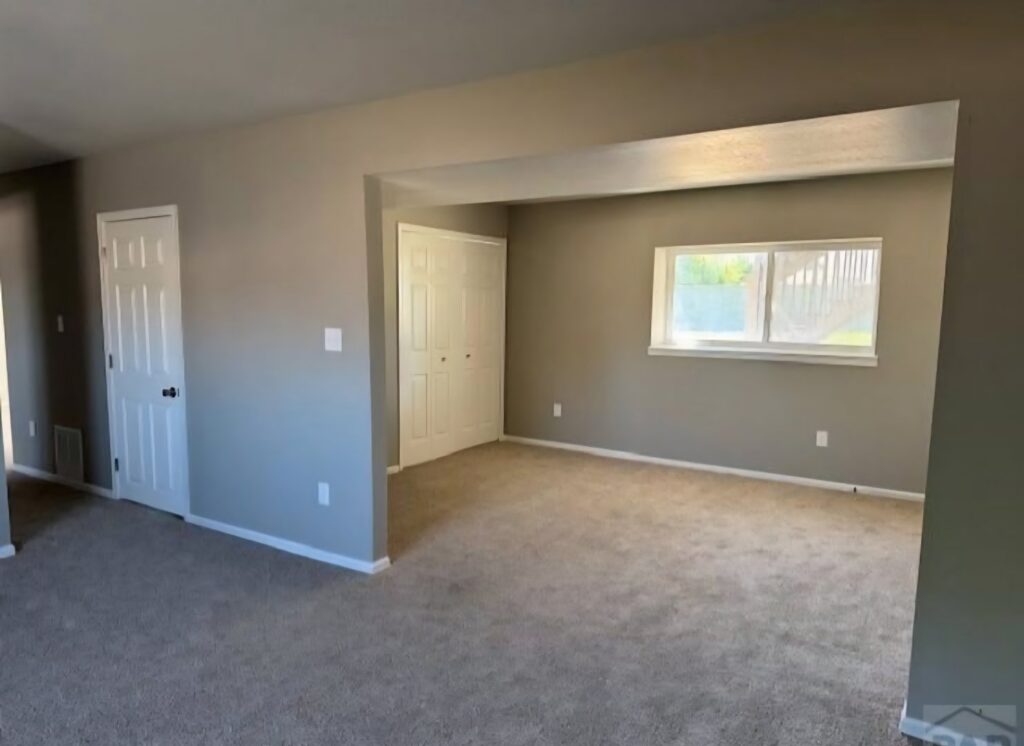 A living room featuring newly installed light brown carpet by Carpet Clearance Warehouse Pueblo, CO.