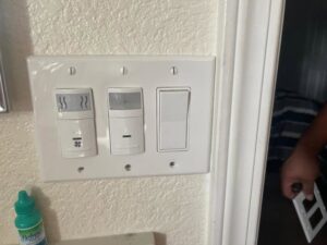 Newly installed light switches and motion sensors on a wall plate, showcasing electrical upgrade work by AAA Electrical Services in Sacramento, CA.