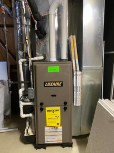 A new Luxaire furnace unit with connected ductwork, installed by Healthy Living Heating and Air Conditioning in Westland, MI.