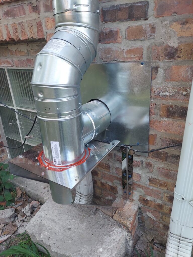A newly installed metal exhaust and ventilation pipe system on a brick wall by Mid-City HVAC, INC. in Chicago, IL.