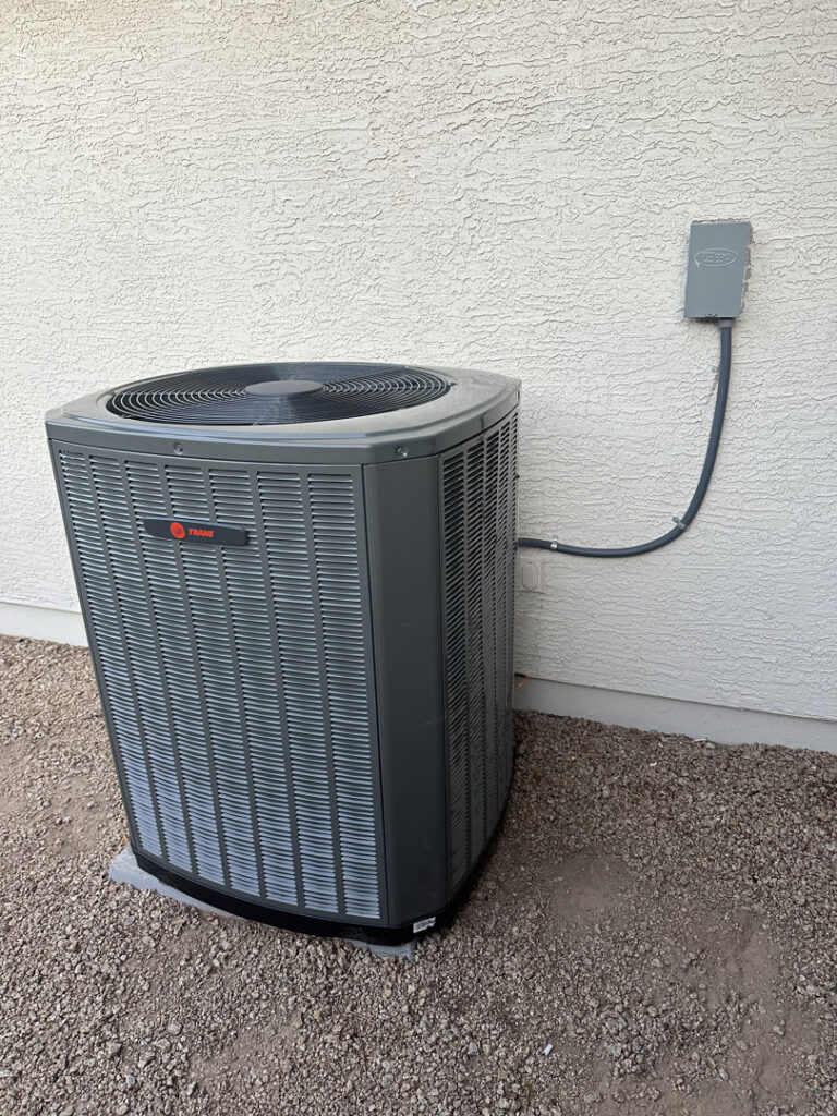 A newly installed outdoor AC condenser unit next to a residential building by Az AC and Heat Services in Queen Creek, AZ.