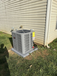 A new outdoor AC condenser unit installed next to a residential building by Dan Deckard Hvac in Charlotte, NC