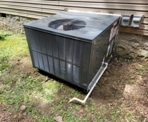 A new outdoor AC condenser unit installed next to a residential building by Smoky Mountain Ducts & Vents in New Market, TN.