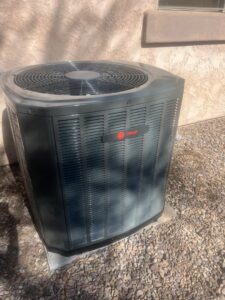 A new outdoor AC condenser unit installed at a residential property by Ash Cooling & Heating in Mesa, AZ.
