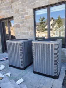 Two new outdoor air conditioning condenser units installed outside a building by Diamond L Plumbing & HVAC in Salt Lake City, UT.
