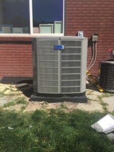 A newly installed outdoor air conditioning unit next to a brick wall by Any Climate Mechanical HVAC in Sandy, UT.