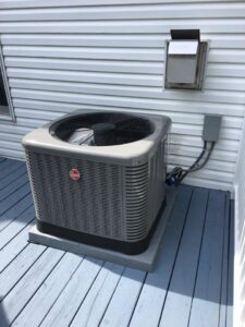 A newly installed outdoor AC unit next to a residential home by Ash Plumbing, Drain & Sewer in Akron, OH.