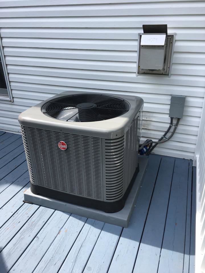 A newly installed outdoor AC unit next to a residential home by Ash Plumbing, Drain & Sewer in Akron, OH.