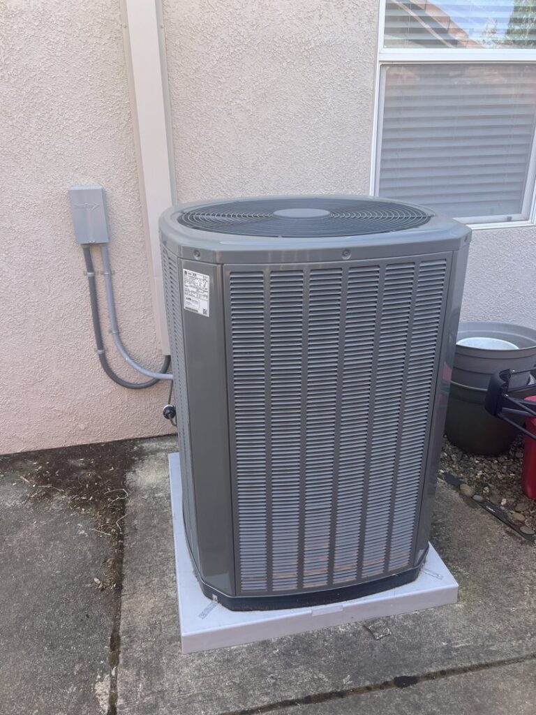 A newly installed outdoor air conditioning unit next to a residential building by Ecology Air Innovations in Sacramento, CA.