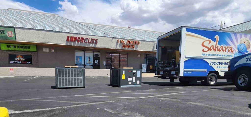 New outdoor air conditioning units and a service truck in a parking lot for Sahara Air Conditioning & Heating in Las Vegas, NV