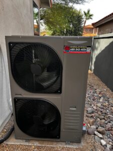 A newly installed outdoor heat pump unit by Arizaz Heating & Cooling next to a residential property in Chandler, AZ.