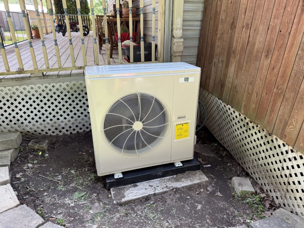 A newly installed outdoor heat pump or air conditioning unit by Wes-Tech Services in Bloomington, IN.