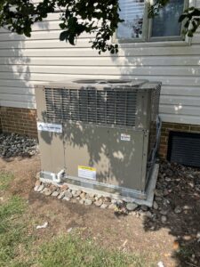 A new outdoor HVAC condenser unit installed next to a residential building by Coastal Breeze Heating-Cooling-Plumbing in Hampton, VA.