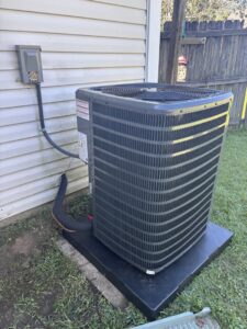 A newly installed outdoor HVAC condenser unit next to a residential building by Grand Slam Heating & Air in Baton Rouge, LA.